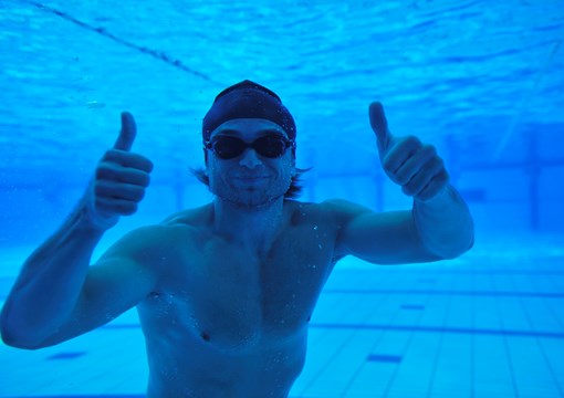 Billede af mand under vand der vender tommelfingrene op