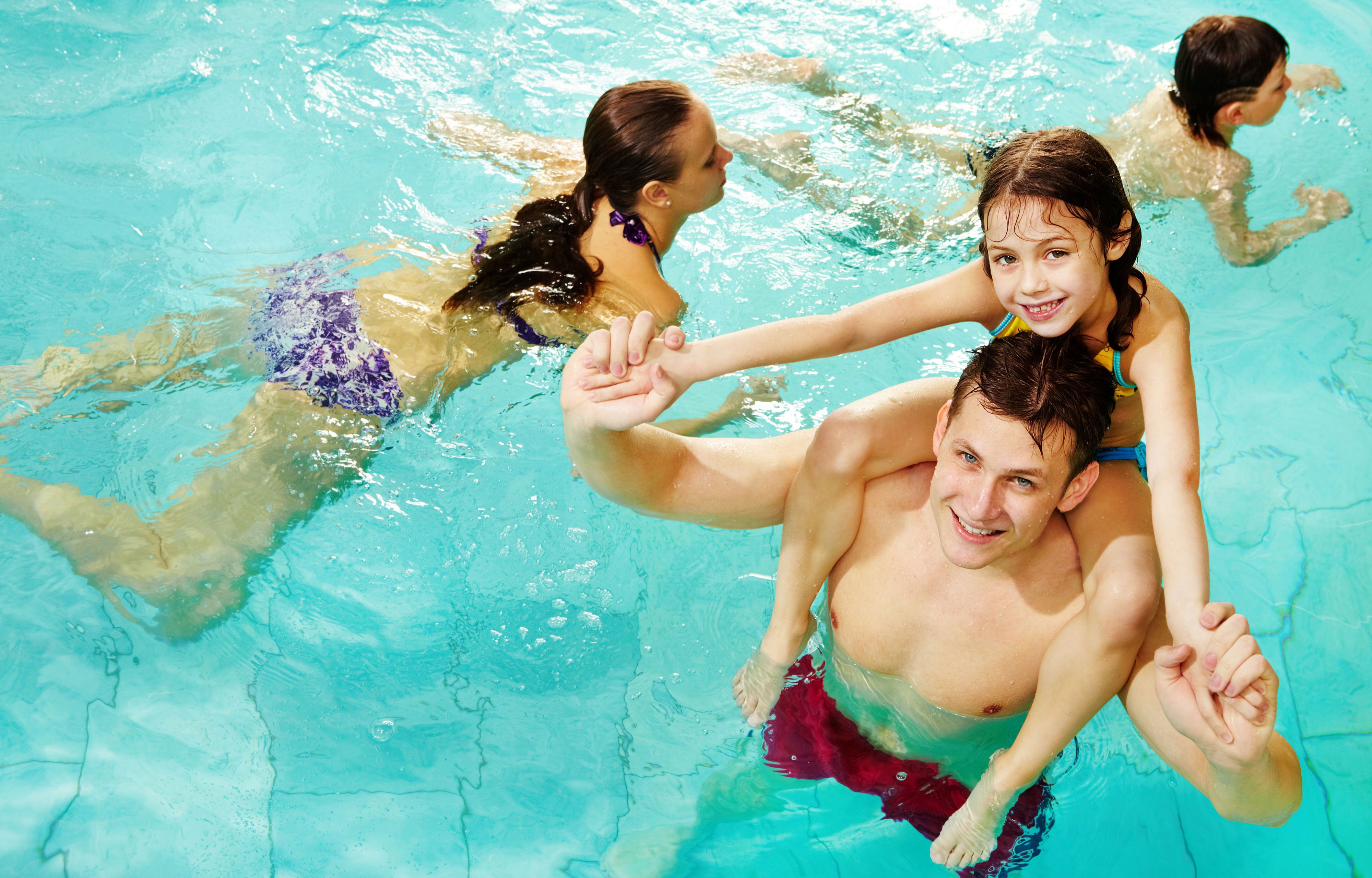 Ung mand med pige på skulderen i vandet